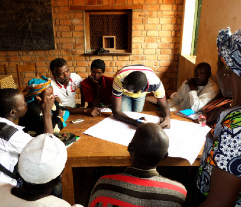 A group sitting around a table, working together in CAR while one man takes notes