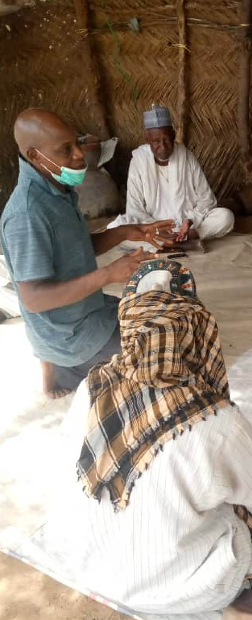 A group of people collaborating and listening to a man speak in Northeast Nigeria